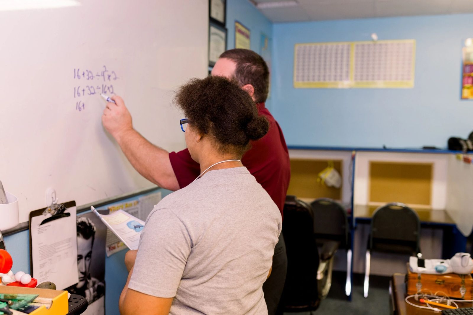 A teacher working with a student at the whiteboard